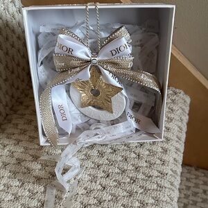 Dior oil infuser ornament in gold and white.